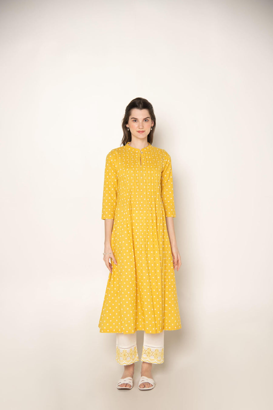 Yellow polka dot pleated A-Line Kurta with white cut-work embroidered Pant.