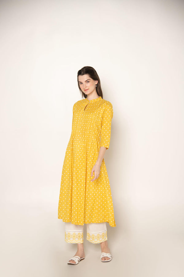 Yellow polka dot pleated A-Line Kurta with white cut-work embroidered Pant.