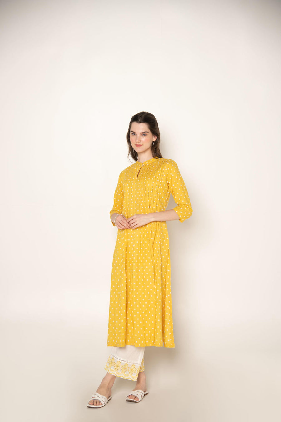 Yellow polka dot pleated A-Line Kurta with white cut-work embroidered Pant.