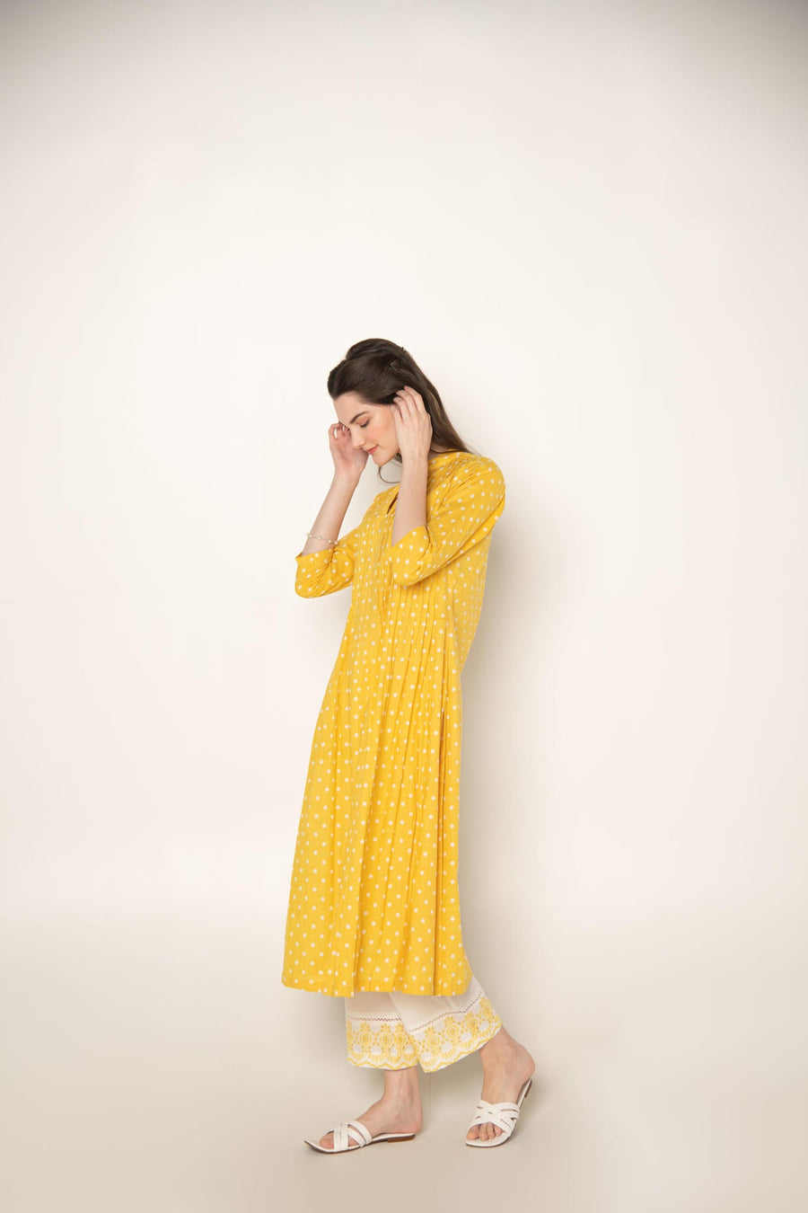 Yellow polka dot pleated A-Line Kurta with white cut-work embroidered Pant.