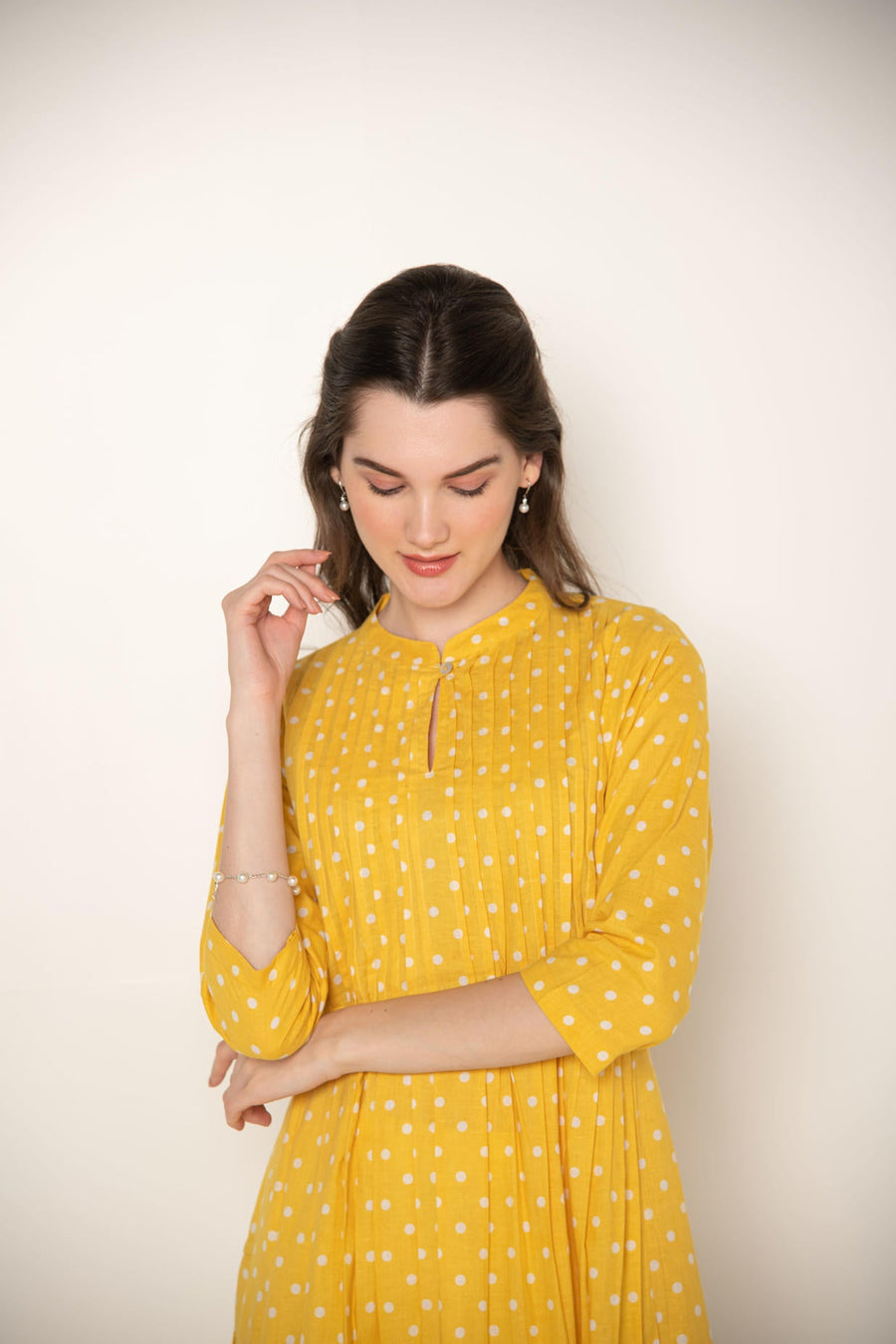 Yellow polka dot pleated A-Line Kurta with white cut-work embroidered Pant.
