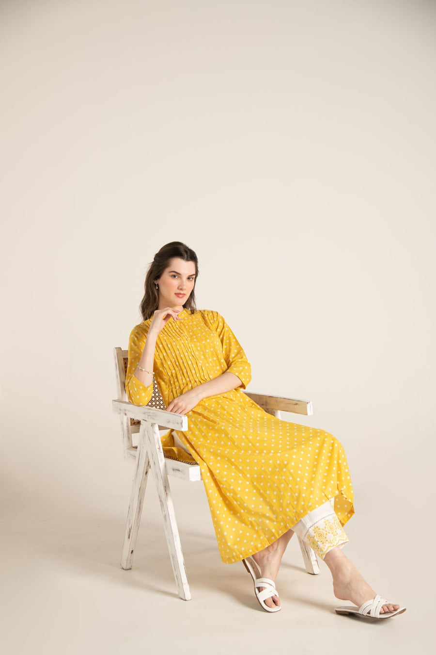 Yellow polka dot pleated A-Line Kurta with white cut-work embroidered Pant.