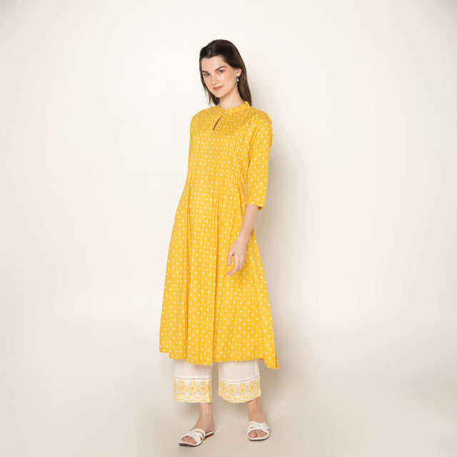 Yellow polka dot pleated A-Line Kurta with white cut-work embroidered Pant.